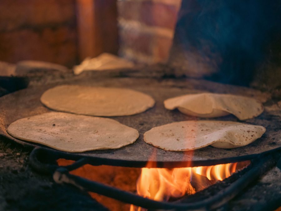 Tortillas de maíz cociéndose sobre un comal a fuego de leña